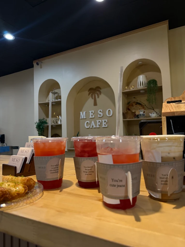 Four drinks on the counter, each sleeve carrying a small arched tag with a message on it